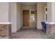 Inviting front porch with brick columns, a wood door, and chairs adding charm and character to the home's entrance at 789 Goodman Cove St, Henderson, NV 89011