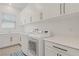 Laundry room with a washer, dryer, storage cabinets, a sink, and a tile floor at 789 Goodman Cove St, Henderson, NV 89011