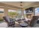 Comfortable covered patio with ample seating, tv, and cozy fireplace at 789 Goodman Cove St, Henderson, NV 89011