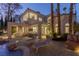Backyard with stone patio, outdoor furniture and seating, lounge chairs, and swimming pool at dusk at 8109 Moonstone Cir, Las Vegas, NV 89128