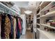 Organized walk-in closet with custom shelving, hanging racks, and elegant chandelier lighting at 8109 Moonstone Cir, Las Vegas, NV 89128