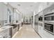 Bright, modern kitchen with white cabinets, stainless steel appliances and large windows at 8109 Moonstone Cir, Las Vegas, NV 89128