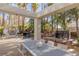 Outdoor dining area and outdoor kitchen with views of the pool and lush landscaping at 8109 Moonstone Cir, Las Vegas, NV 89128