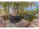 Outdoor seating area and dining table surrounded by tropical landscaping and mature trees at 8109 Moonstone Cir, Las Vegas, NV 89128