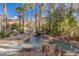 Backyard pool area featuring rock waterfall, lounging chairs, and swing with lush landscaping and palm trees at 8109 Moonstone Cir, Las Vegas, NV 89128