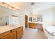 Bathroom featuring double sinks, large mirrors, and a tub with glass shower doors at 853 Ashford Way, Henderson, NV 89015