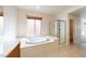 Bathroom showcasing a large tub, glass-enclosed shower, and window for natural light at 853 Ashford Way, Henderson, NV 89015