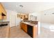 Well-lit kitchen with wooden cabinets, granite counters, a tile floor, and open access to other living spaces at 853 Ashford Way, Henderson, NV 89015