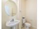 Clean powder room with a pedestal sink, round mirror, and efficient toilet at 853 Ashford Way, Henderson, NV 89015