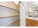 Walk-in closet with white walls, wooden shelves, and tile flooring near the vanity at 853 Ashford Way, Henderson, NV 89015