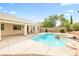 An in-ground pool is surrounded by a spacious patio, with a covered patio, landscaping, and a privacy fence at 9539 Iris Flat Ct, Las Vegas, NV 89178