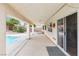 Covered patio with textured concrete, ceiling fan, and outdoor access, leading to a refreshing pool and backyard oasis at 9539 Iris Flat Ct, Las Vegas, NV 89178