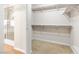 A walk-in closet features carpet, white shelving, and some visibility into a shower area, offering a great storage solution at 9539 Iris Flat Ct, Las Vegas, NV 89178