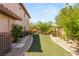 Side yard featuring artificial turf and mature trees at 2285 Villefort Ct, Las Vegas, NV 89117