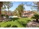 Expansive backyard featuring lush green lawns, mature trees, and a sparkling pool at 2285 Villefort Ct, Las Vegas, NV 89117