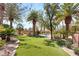 Landscaped backyard with artificial turf, mature trees, and rock features at 2285 Villefort Ct, Las Vegas, NV 89117