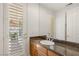 Bathroom with granite countertop, wooden cabinets, large mirror, and door to back patio at 2285 Villefort Ct, Las Vegas, NV 89117