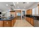 Gourmet kitchen featuring stainless steel appliances, sleek countertops, an island with a cooktop, and tiled flooring at 2285 Villefort Ct, Las Vegas, NV 89117
