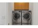 Modern laundry area featuring front-load washer and dryer and cabinets for organized storage at 2285 Villefort Ct, Las Vegas, NV 89117