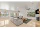 Spacious living area with plush gray sectional sofa, multiple windows, and tile flooring, creating a comfortable space at 2285 Villefort Ct, Las Vegas, NV 89117