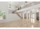 Open-concept living room with tall staircase and windows providing natural light and tile flooring at 2285 Villefort Ct, Las Vegas, NV 89117