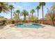 Tranquil pool with rock waterfall surrounded by palm trees and lush landscaping at 2285 Villefort Ct, Las Vegas, NV 89117