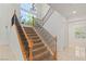 Grand staircase with wood banister, iron spindles, and large window at 2285 Villefort Ct, Las Vegas, NV 89117