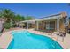 Lush backyard featuring a sparkling pool, covered patio, and mature trees, creating a serene oasis at 315 Barletta Ave, Las Vegas, NV 89123