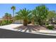 Charming single-story home with a three-car garage and lush landscaping, including mature palm trees at 315 Barletta Ave, Las Vegas, NV 89123