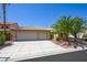 Charming single-story home with a three-car garage and lush landscaping, including mature palm trees at 315 Barletta Ave, Las Vegas, NV 89123