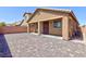 Spacious backyard featuring a covered patio, brick privacy wall, and paver stones at 7137 Flowering Rose Ave, Las Vegas, NV 89117