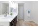 Well-lit bathroom with dual sinks, modern faucets, and a linen closet for added storage at 7137 Flowering Rose Ave, Las Vegas, NV 89117