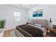 This staged bedroom is bright and airy with wood-look floors and a large window for natural light at 7137 Flowering Rose Ave, Las Vegas, NV 89117