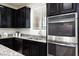 Close-up of oven with modern oven and stainless steel sink with goose neck faucet and granite countertops at 7137 Flowering Rose Ave, Las Vegas, NV 89117