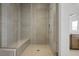 The walk-in shower is fully tiled, has a glass door, a built-in bench, and modern fixtures for a luxurious feel at 8863 Italian Trotter Ct, Las Vegas, NV 89113