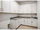 Bright laundry room with white cabinets, gray countertops and wood-look tile floors at 8863 Italian Trotter Ct, Las Vegas, NV 89113