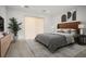 The staged primary bedroom showcases a plush bed, stylish decor, and sliding glass doors to bring in plenty of light at 8863 Italian Trotter Ct, Las Vegas, NV 89113