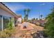 Spacious backyard with mature trees, palm trees, and a cozy patio area for outdoor enjoyment at 90 Ancient Hills Ln, Henderson, NV 89074