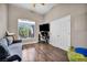 Bright bedroom with a large window, hardwood floors, closet, and comfortable gray couch at 90 Ancient Hills Ln, Henderson, NV 89074