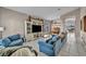 Spacious living room with tile flooring, a large TV, blue couches, and elegant decor at 90 Ancient Hills Ln, Henderson, NV 89074