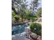 Backyard waterfall feature with lush greenery at 9705 Floweret Ave, Las Vegas, NV 89117