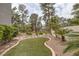 Landscaped backyard featuring artificial turf and tropical greenery at 9705 Floweret Ave, Las Vegas, NV 89117