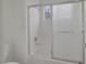 Bathroom includes a bathtub with sliding glass doors and white tiling at 9705 Floweret Ave, Las Vegas, NV 89117