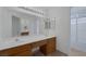 Bathroom features double sink vanity with wood cabinets and large mirror at 9705 Floweret Ave, Las Vegas, NV 89117
