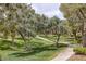 A serene park view with walking paths winding through lush green grass and mature trees at 9705 Floweret Ave, Las Vegas, NV 89117