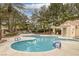 Community pool view with wading pool, chairs, mature trees, and playground nearby at 9705 Floweret Ave, Las Vegas, NV 89117