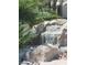 Waterfall feature with rocks and tropical plants at 9705 Floweret Ave, Las Vegas, NV 89117