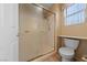 Bathroom featuring a tiled shower, toilet, and a frosted window for natural light at 9917 Arbuckle Dr, Las Vegas, NV 89134