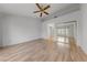 Bright bedroom featuring wood floors, modern fan, and mirrored closet doors at 9917 Arbuckle Dr, Las Vegas, NV 89134