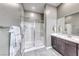 Contemporary bathroom featuring a glass-enclosed shower, large mirror, and elegant vanity with modern fixtures at 109 Reverie Heights Ave, Henderson, NV 89011